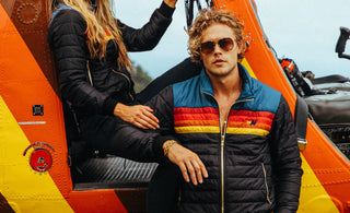 Models posing in outerwear in-front of helicopter