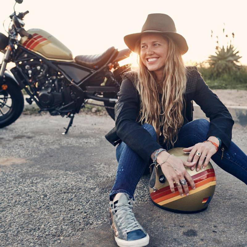 Paige Mycoskie posing in front of a motorcycle