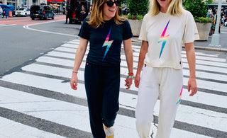 Two women walking across the street in NYC wearing Aviator Nation