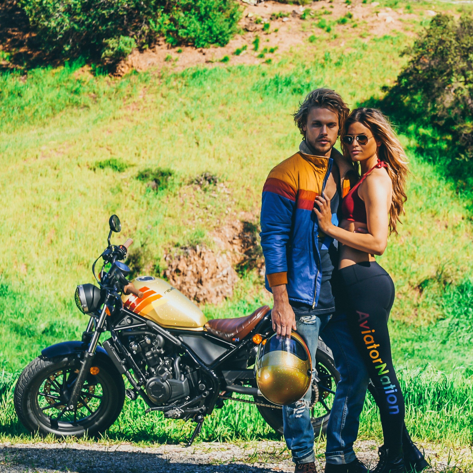 Two models posing in front of a motorcycle