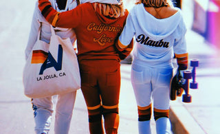 3 girls walking down the street dressed in Aviator Nation sweatsuits
