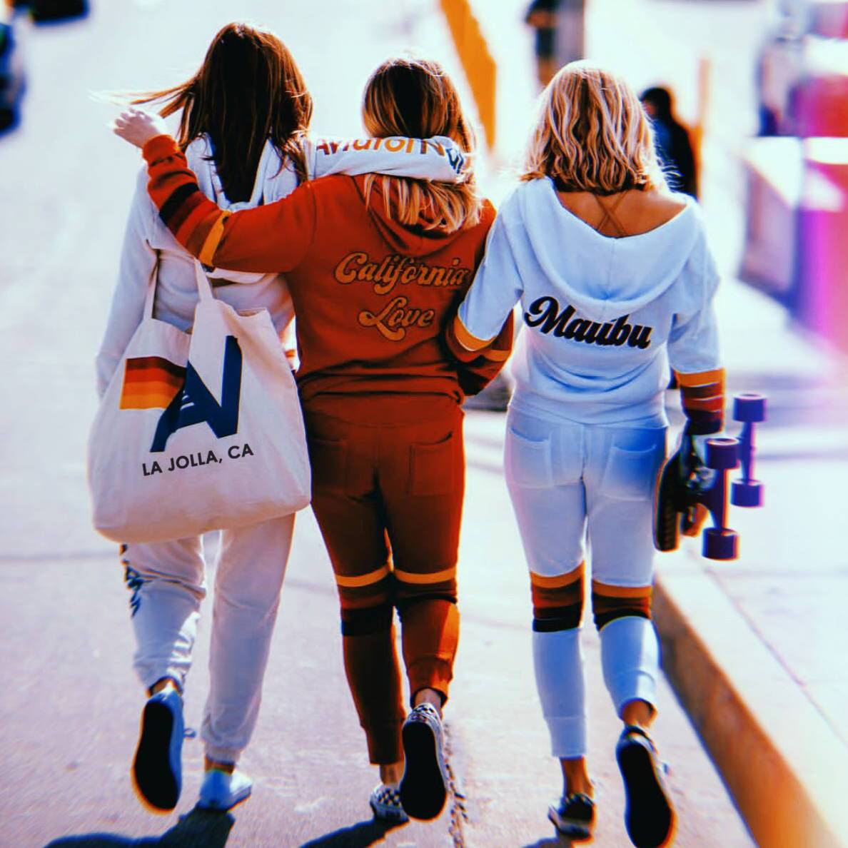 3 girls walking down the street dressed in Aviator Nation sweatsuits