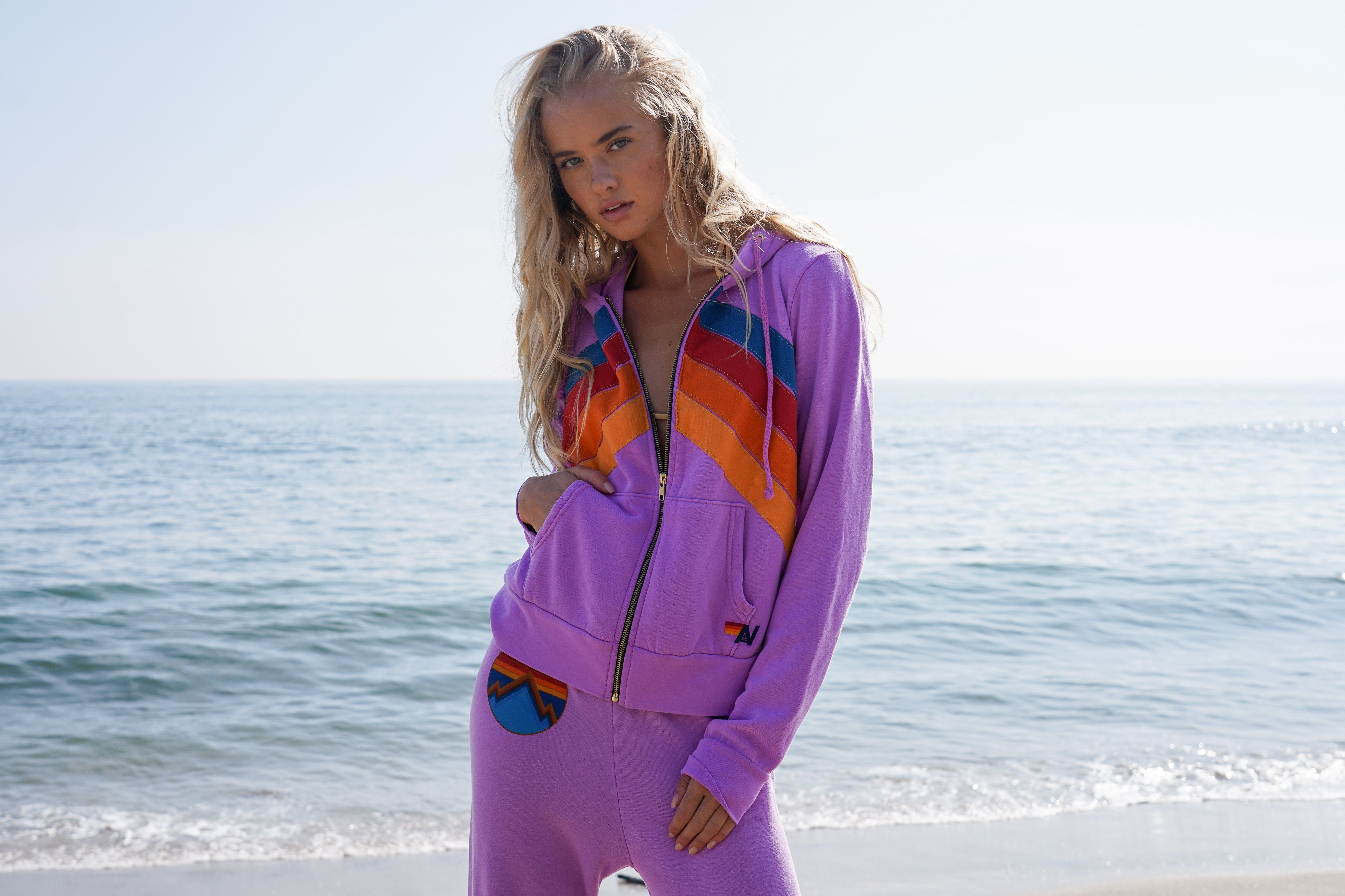Woman wearing a colorful outfit on a beach with ocean in the background